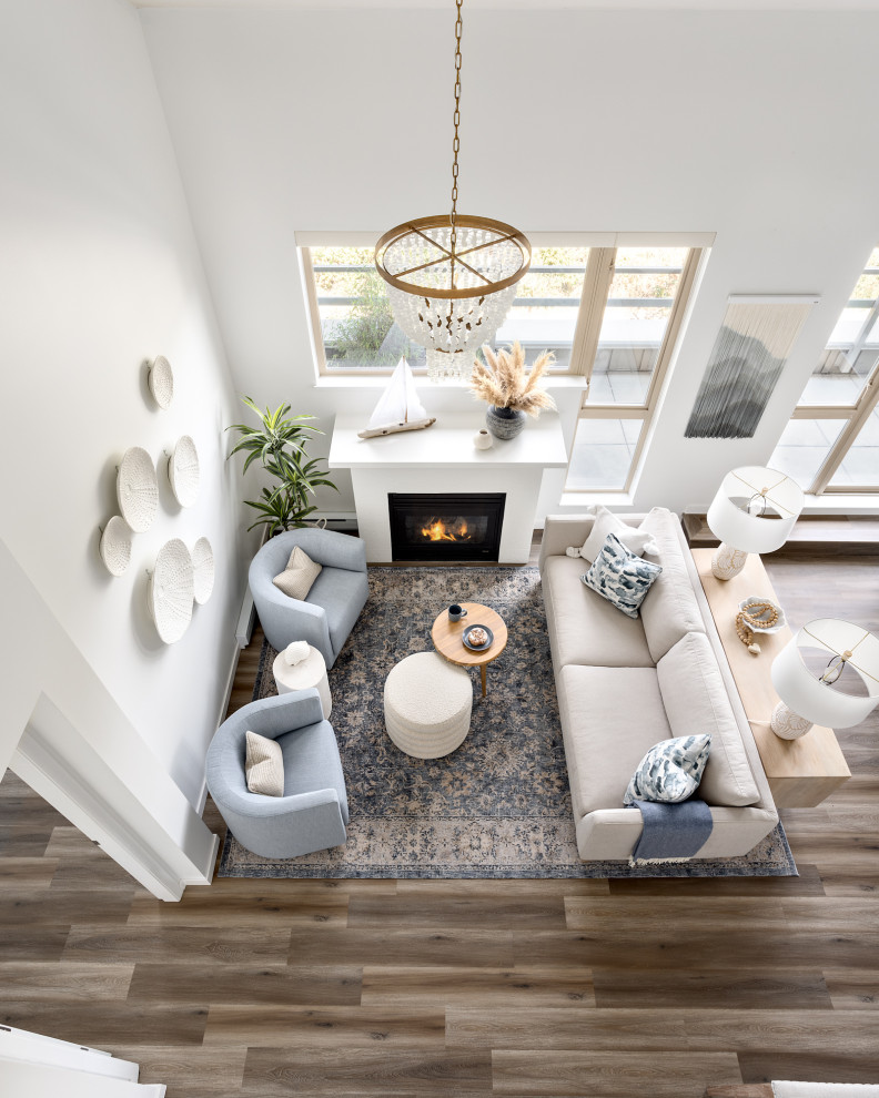 Design ideas for a medium sized nautical open plan living room in Vancouver with white walls, a standard fireplace, a plastered fireplace surround and beige floors.