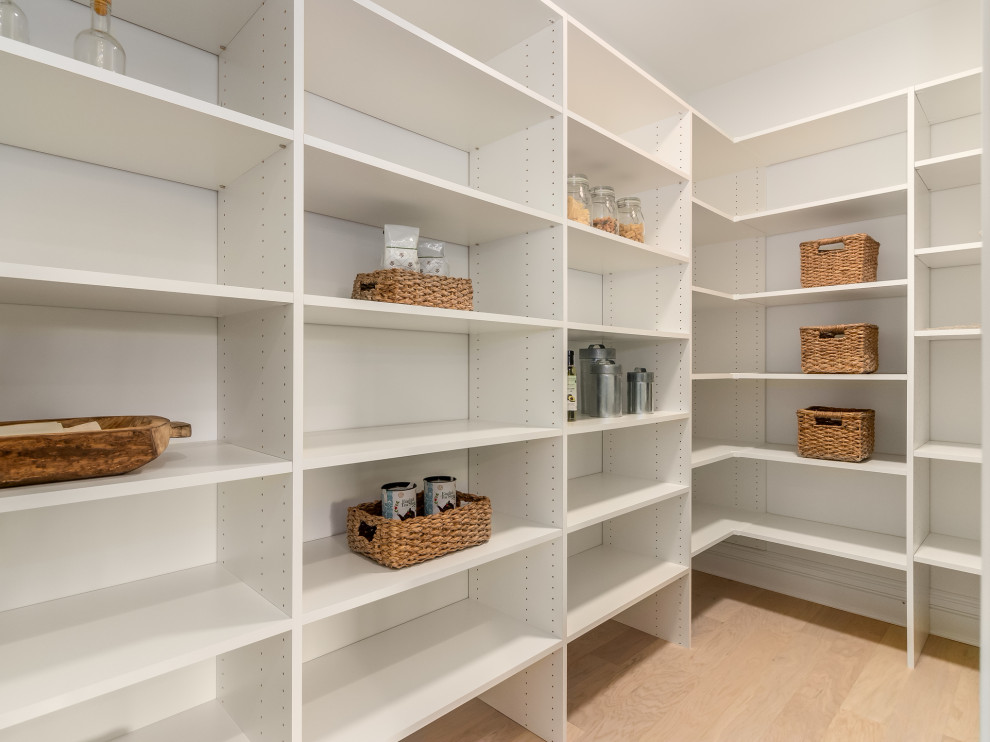 Large gender-neutral storage and wardrobe in Chicago with light hardwood floors and beige floor.