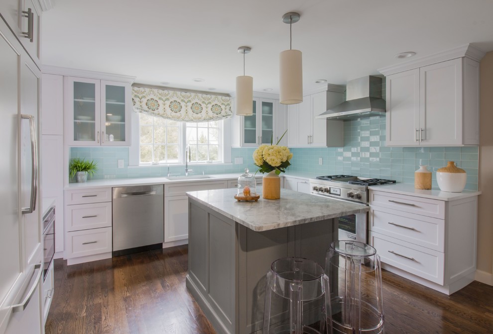 Photo of a mid-sized traditional u-shaped kitchen in Boston with an undermount sink, white cabinets, quartz benchtops, blue splashback, glass tile splashback, stainless steel appliances, with island, shaker cabinets, dark hardwood floors and brown floor.
