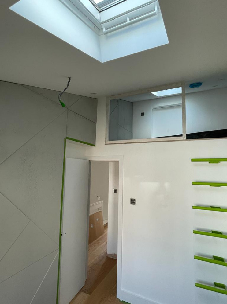 Idee per una camera da letto stile loft design con pareti bianche, parquet chiaro, soffitto a volta e pannellatura
