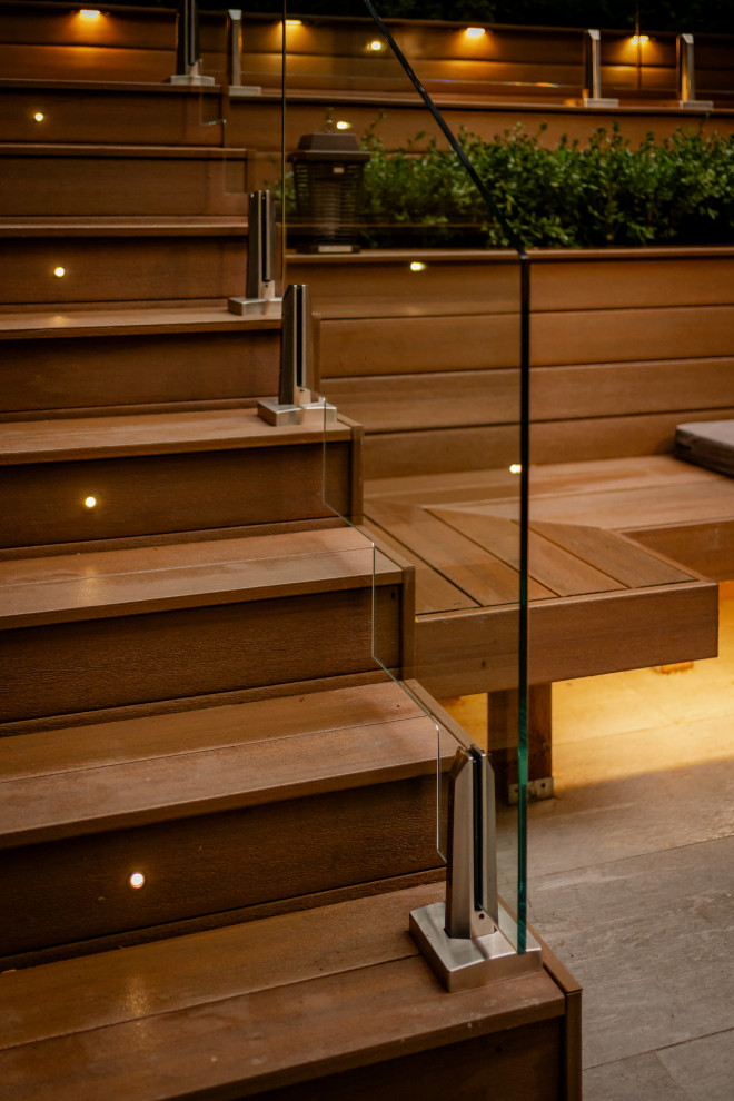 На фото: маленькая прямая деревянная лестница в современном стиле с деревянными ступенями, стеклянными перилами и деревянными стенами для на участке и в саду с