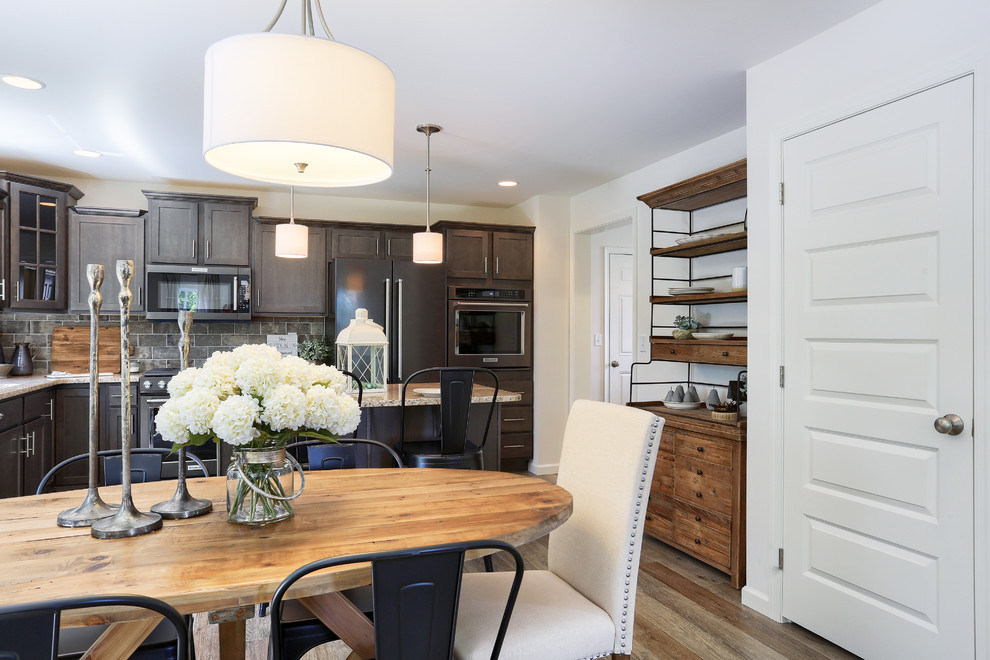 Open concept kitchen - mid-sized transitional l-shaped medium tone wood floor and brown floor open concept kitchen idea with a single-bowl sink, recessed-panel cabinets, dark wood cabinets, granite countertops, gray backsplash, stainless steel appliances and an island