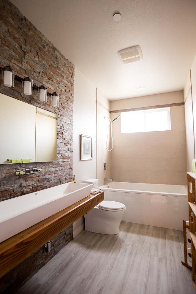 Inspiration for a mid-sized contemporary kids bathroom in Seattle with open cabinets, brown cabinets, an alcove tub, a shower/bathtub combo, a one-piece toilet, beige tile, porcelain tile, beige walls, porcelain floors, a trough sink, wood benchtops, brown floor, a shower curtain and brown benchtops.