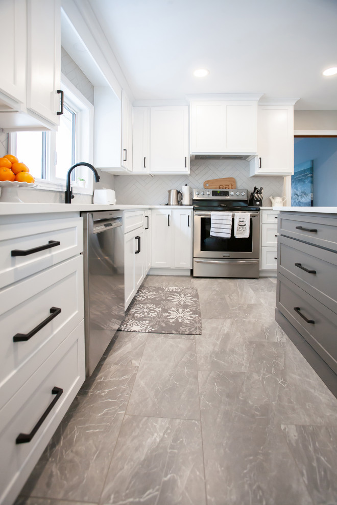 Mid-sized transitional l-shaped gray floor enclosed kitchen photo with an undermount sink, shaker cabinets, white cabinets, quartz countertops, gray backsplash, ceramic backsplash, stainless steel appliances, an island and white countertops
