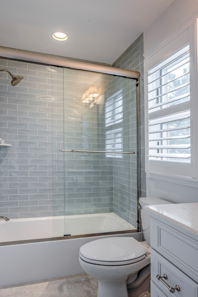 Design ideas for a small beach style 3/4 bathroom in Other with recessed-panel cabinets, white cabinets, an alcove tub, a shower/bathtub combo, a two-piece toilet, gray tile, subway tile, white walls, an undermount sink, granite benchtops, a sliding shower screen and white benchtops.