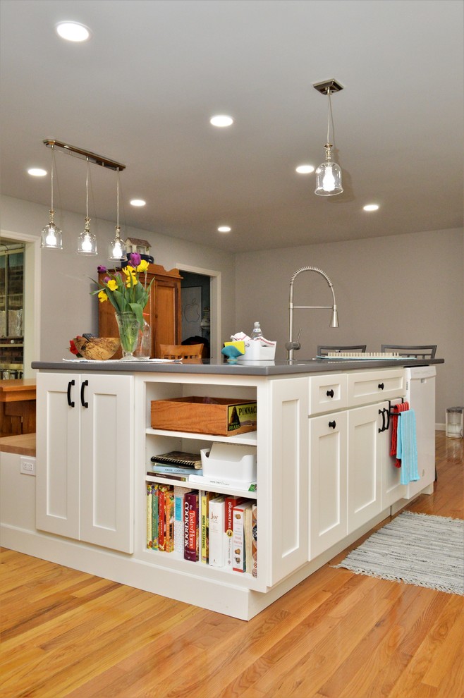 Design ideas for a large transitional u-shaped eat-in kitchen in Indianapolis with an undermount sink, recessed-panel cabinets, white cabinets, solid surface benchtops, white splashback, subway tile splashback, stainless steel appliances, medium hardwood floors, with island, brown floor and grey benchtop.