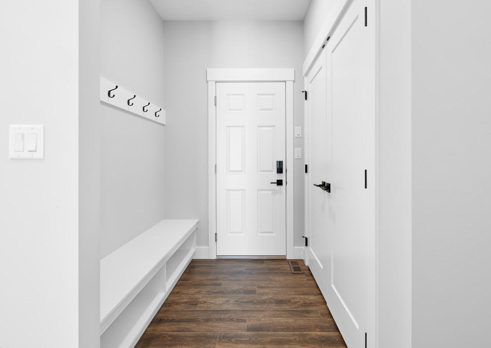 Exempel på ett mellanstort modernt kapprum, med grå väggar, mörkt trägolv, en enkeldörr, en vit dörr och brunt golv