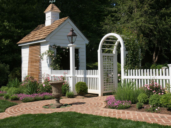 Inspiration for a mid-sized traditional side yard formal garden in DC Metro with a garden path and brick pavers.