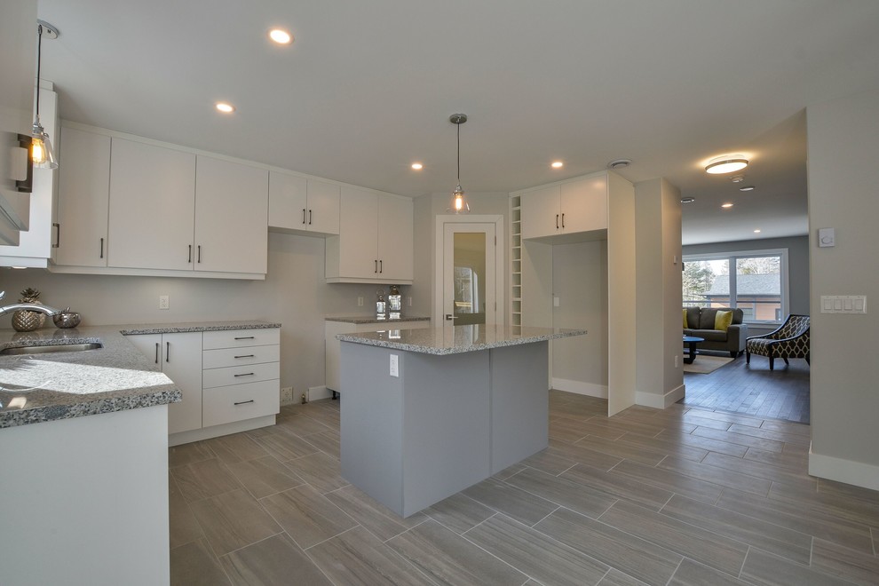 Eat-in kitchen - mid-sized transitional ceramic tile and gray floor eat-in kitchen idea with an undermount sink, flat-panel cabinets, white cabinets, granite countertops, an island and gray countertops