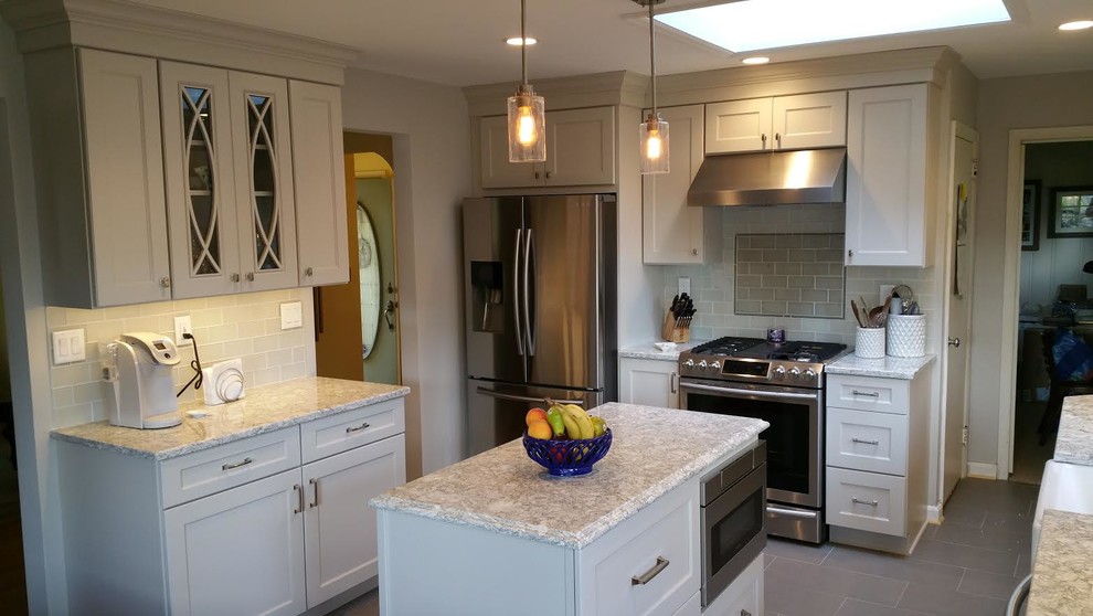This is an example of a small traditional l-shaped separate kitchen in New York with a farmhouse sink, shaker cabinets, white cabinets, granite benchtops, grey splashback, ceramic splashback, stainless steel appliances, ceramic floors and with island.