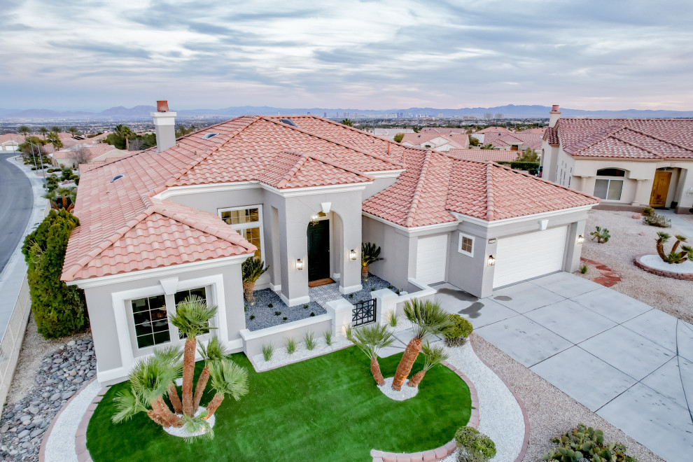 This is an example of a large and gey contemporary bungalow detached house in Las Vegas with a red roof.