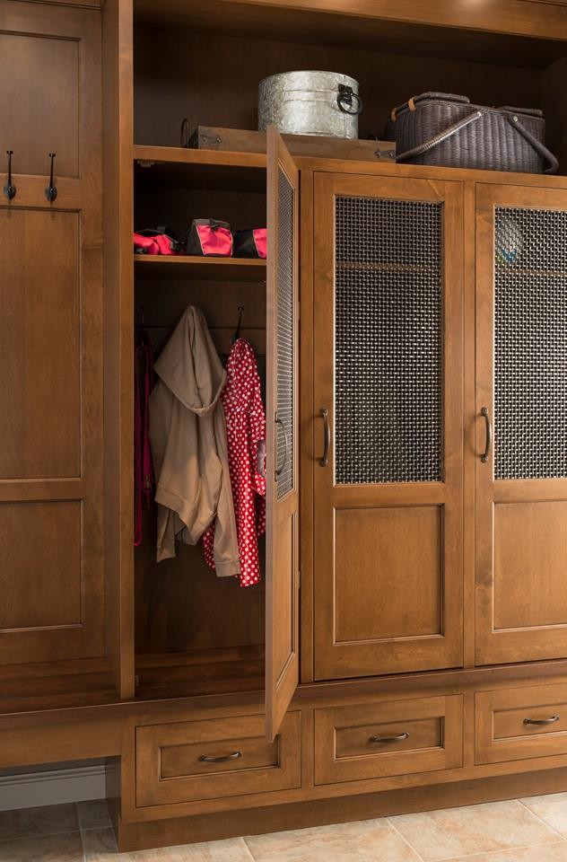 Photo of a large traditional gender-neutral built-in wardrobe in Houston with beaded inset cabinets, medium wood cabinets and terra-cotta floors.