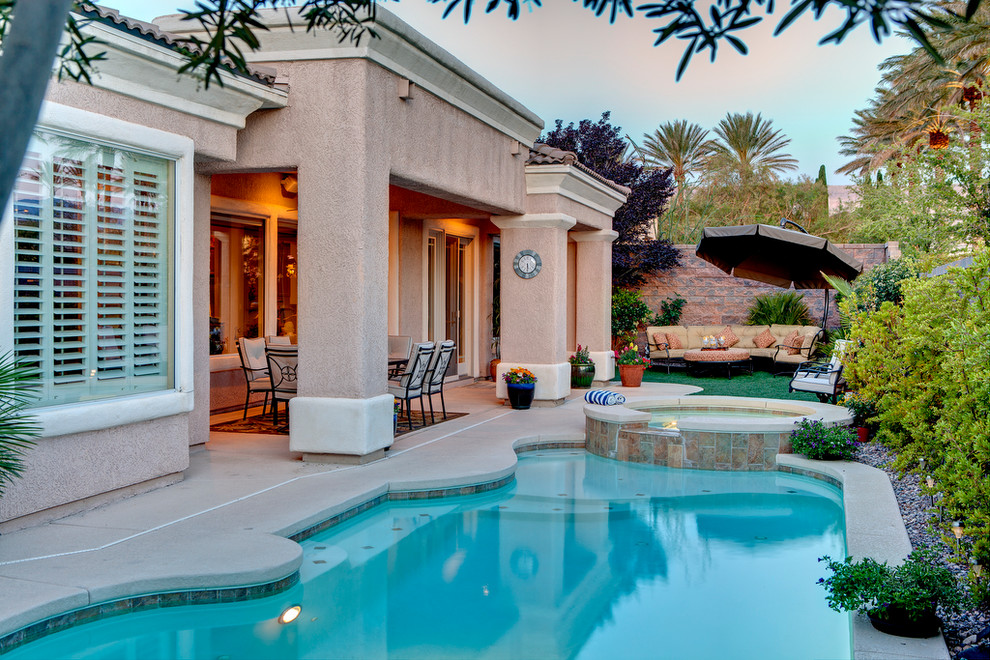 Inspiration for a mid-sized traditional backyard custom-shaped pool in Las Vegas with a hot tub and decking.