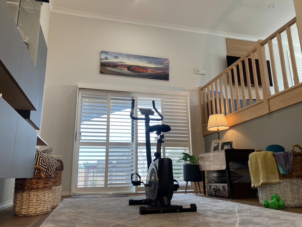 Photo of a large contemporary home gym in Perth with multi-coloured walls, dark hardwood flooring and brown floors.