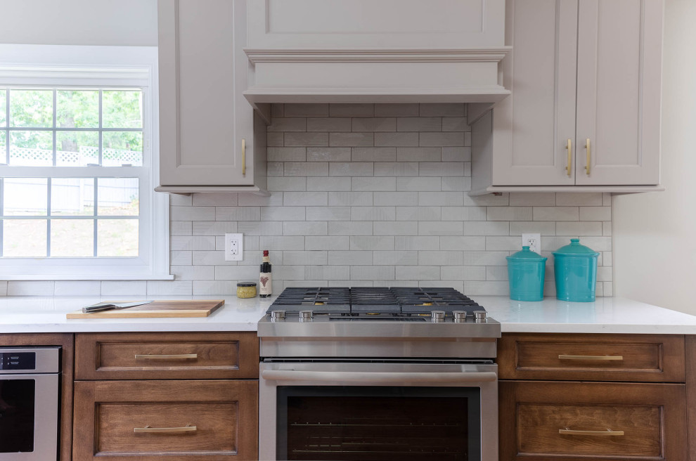 Example of a transitional kitchen design with subway tile backsplash and stainless steel appliances