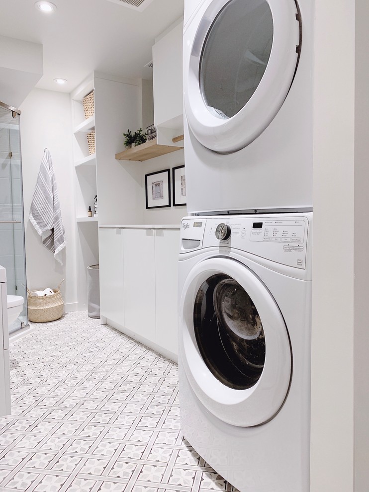 Design ideas for a contemporary laundry room in Toronto with flat-panel cabinets, white cabinets, quartz benchtops, white walls, porcelain floors, a stacked washer and dryer and white benchtop.