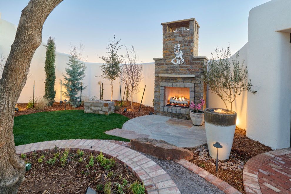 This is an example of a small eclectic courtyard xeriscape in Other with with fireplace and natural stone pavers.