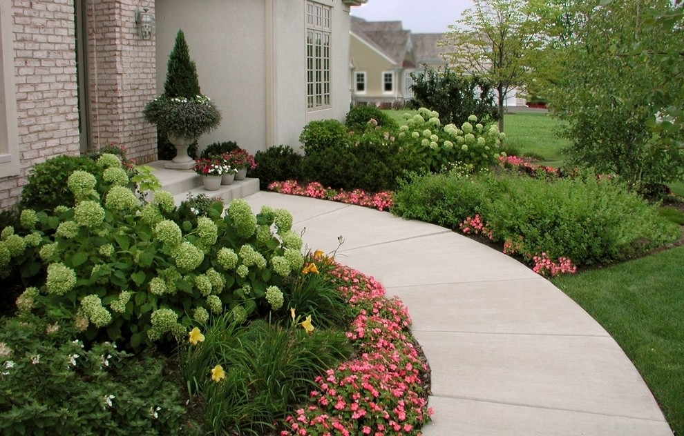 This is an example of a large traditional front yard garden in Chicago with concrete pavers.
