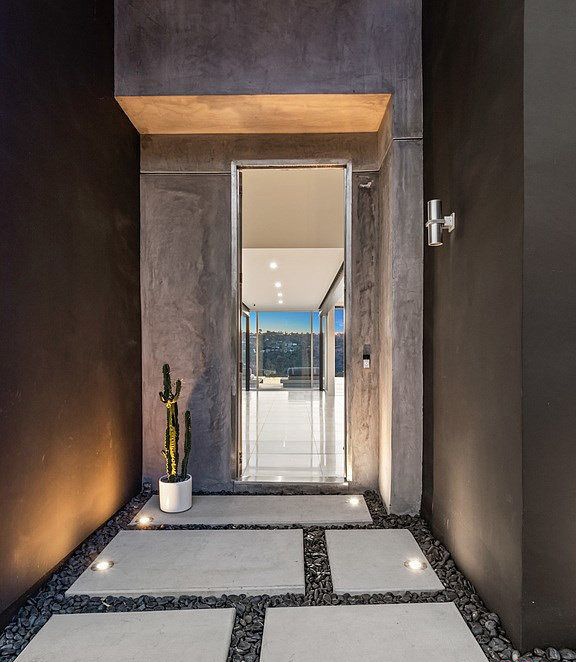 Aménagement d'un hall d'entrée moderne de taille moyenne avec un mur gris, sol en béton ciré, une porte simple, une porte métallisée et un sol gris.