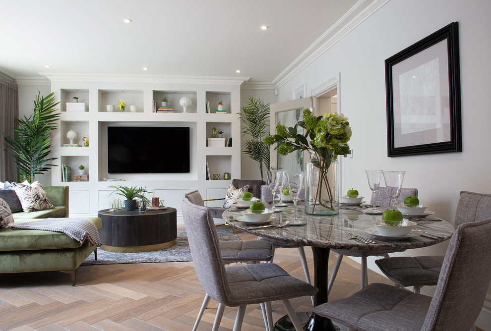 Contemporary open plan dining in London with white walls, medium hardwood floors, no fireplace and brown floor.