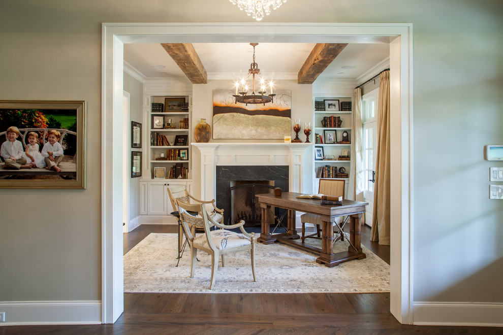 Mid-sized traditional study room in Nashville with beige walls, dark hardwood floors, a standard fireplace, a stone fireplace surround and a freestanding desk.