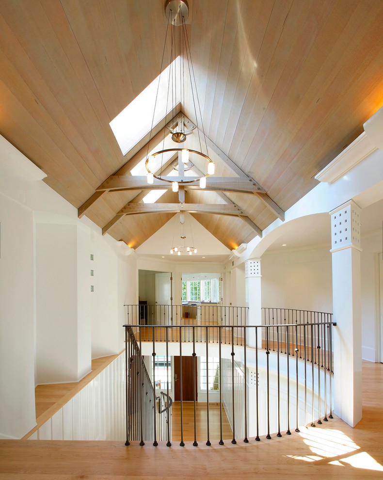 Photo of a large beach style hallway in New York with white walls and medium hardwood floors.