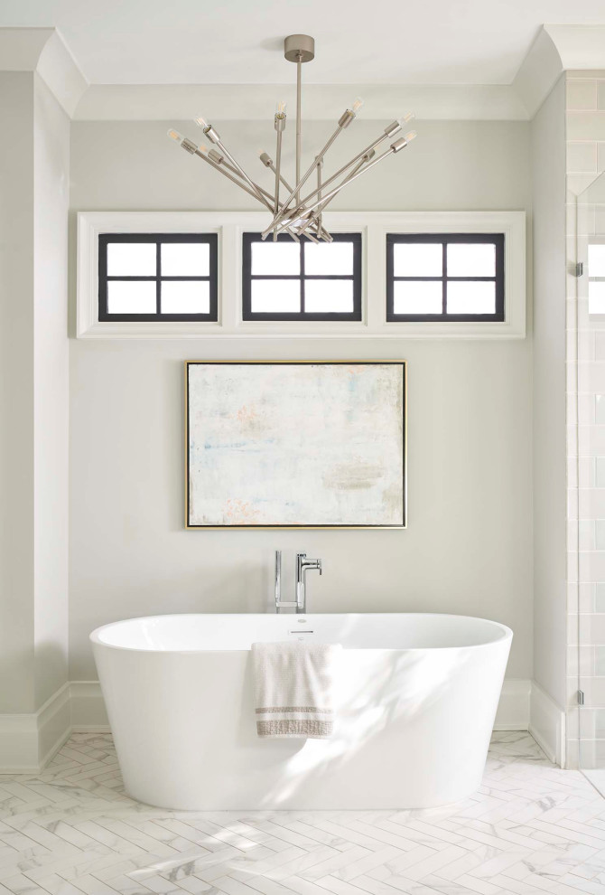 This is an example of a transitional bathroom in Charlotte with a freestanding tub, grey walls and white floor.