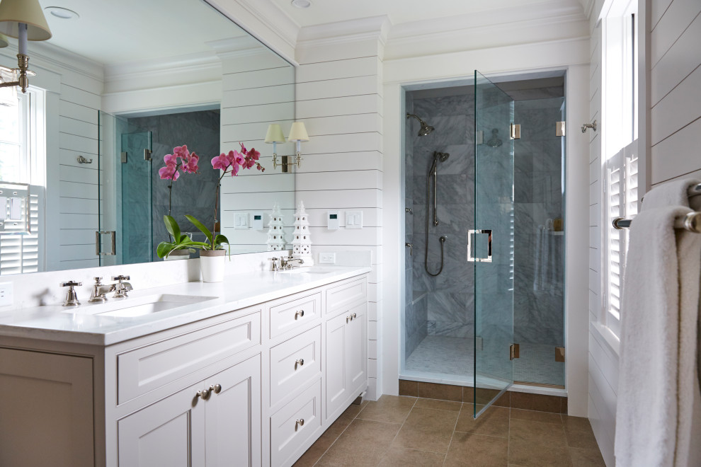 Photo of a country bathroom in Boston with beaded inset cabinets, grey cabinets, an alcove shower, gray tile, white walls, an undermount sink, brown floor, a hinged shower door, white benchtops, a shower seat, a double vanity and a built-in vanity.