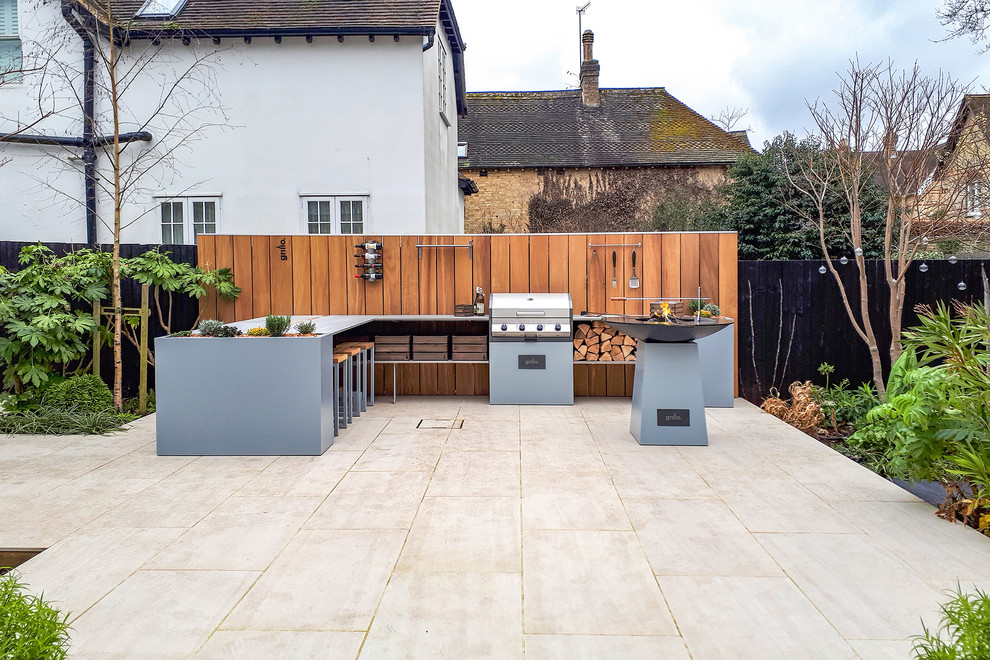 Photo of a mid-sized contemporary backyard patio in Other with an outdoor kitchen, no cover and natural stone pavers.