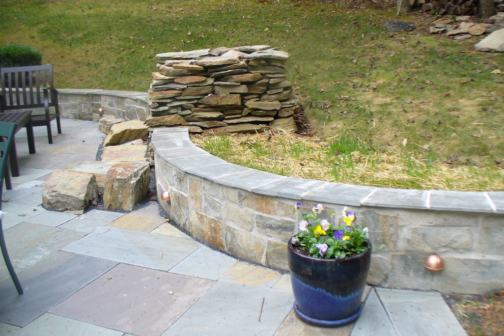 Photo of a mid-sized traditional backyard patio in DC Metro with a fire feature, natural stone pavers and no cover.