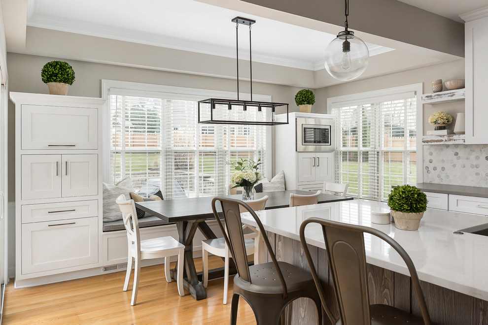 Example of a large transitional light wood floor open concept kitchen design in Chicago with an undermount sink, shaker cabinets, white cabinets, quartz countertops, gray backsplash, marble backsplash, stainless steel appliances and an island
