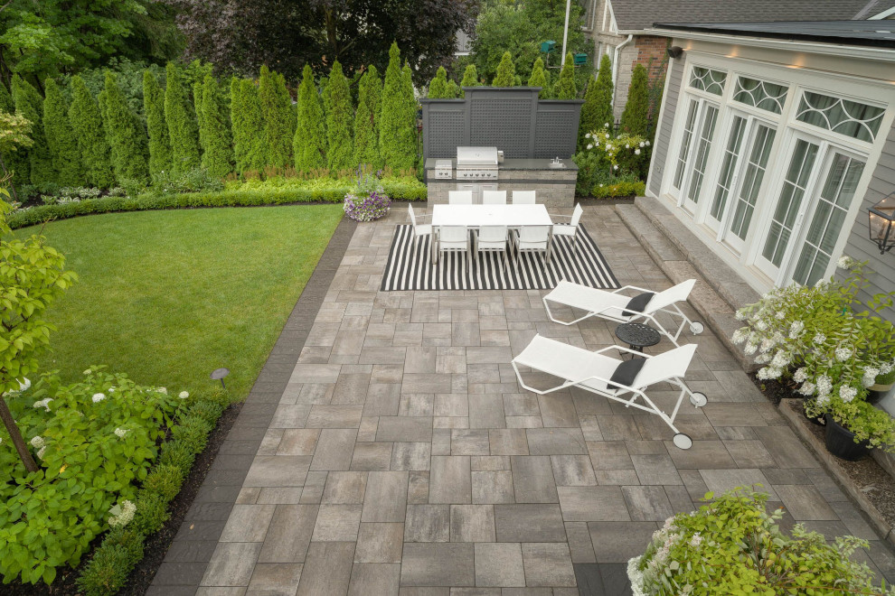 Design ideas for a large contemporary backyard garden in Toronto with natural stone pavers.