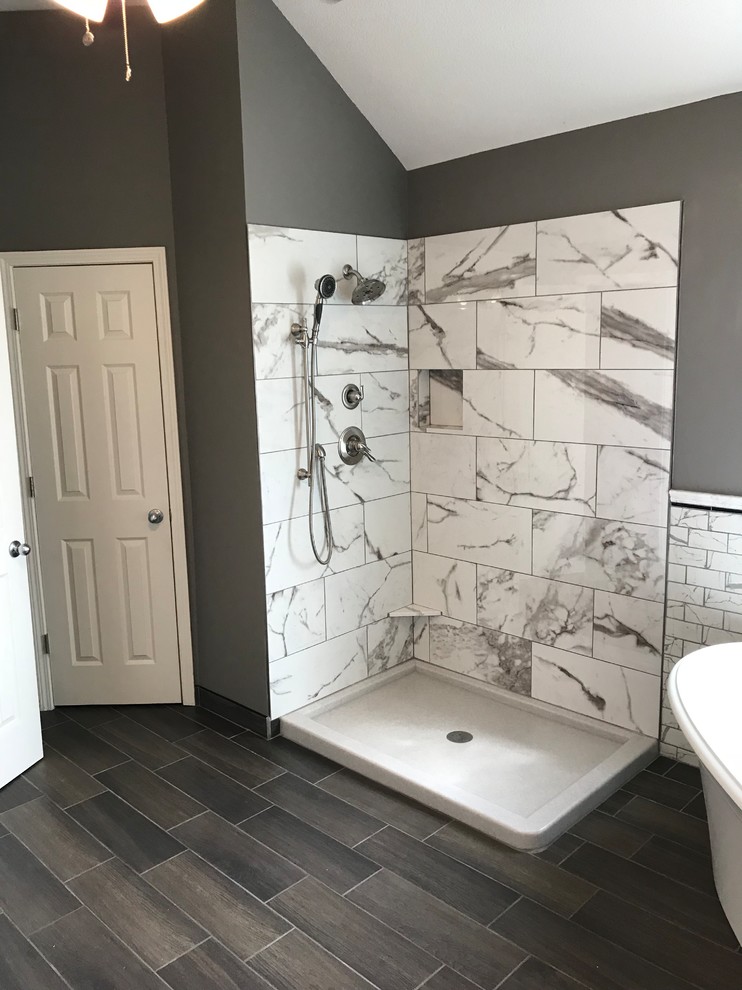 Mid-sized transitional master bathroom in Kansas City with grey cabinets, a freestanding tub, a corner shower, a two-piece toilet, gray tile, porcelain tile, grey walls, ceramic floors, an undermount sink, engineered quartz benchtops and brown floor.