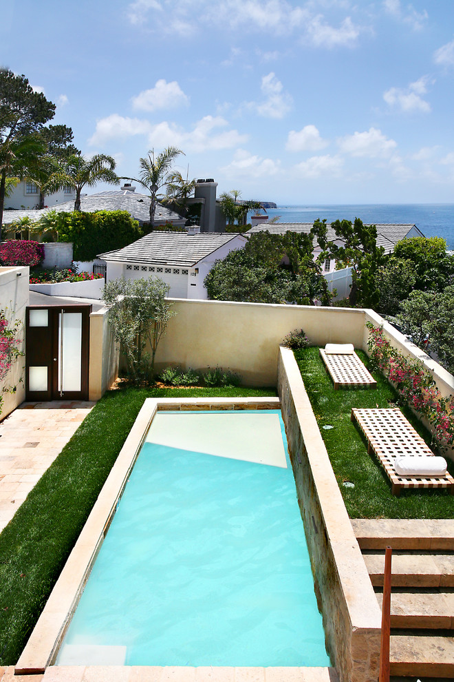 Inspiration for a mid-sized mediterranean backyard rectangular lap pool in Orange County with natural stone pavers.