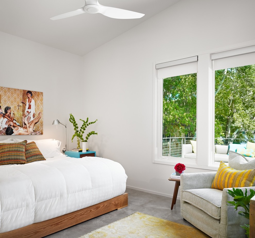 This is an example of a midcentury bedroom in Austin with white walls and concrete floors.