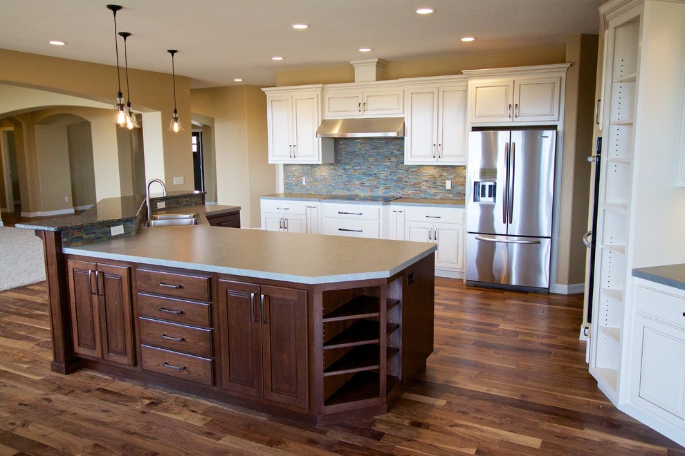 Inspiration for a huge open concept kitchen remodel with a drop-in sink, raised-panel cabinets, white cabinets, multicolored backsplash, stone tile backsplash, stainless steel appliances and an island
