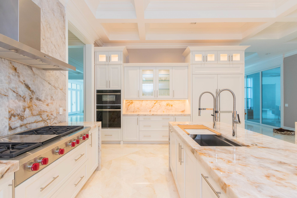Example of a huge transitional u-shaped marble floor and white floor open concept kitchen design with an undermount sink, flat-panel cabinets, white cabinets, quartzite countertops, white backsplash, stone slab backsplash and two islands