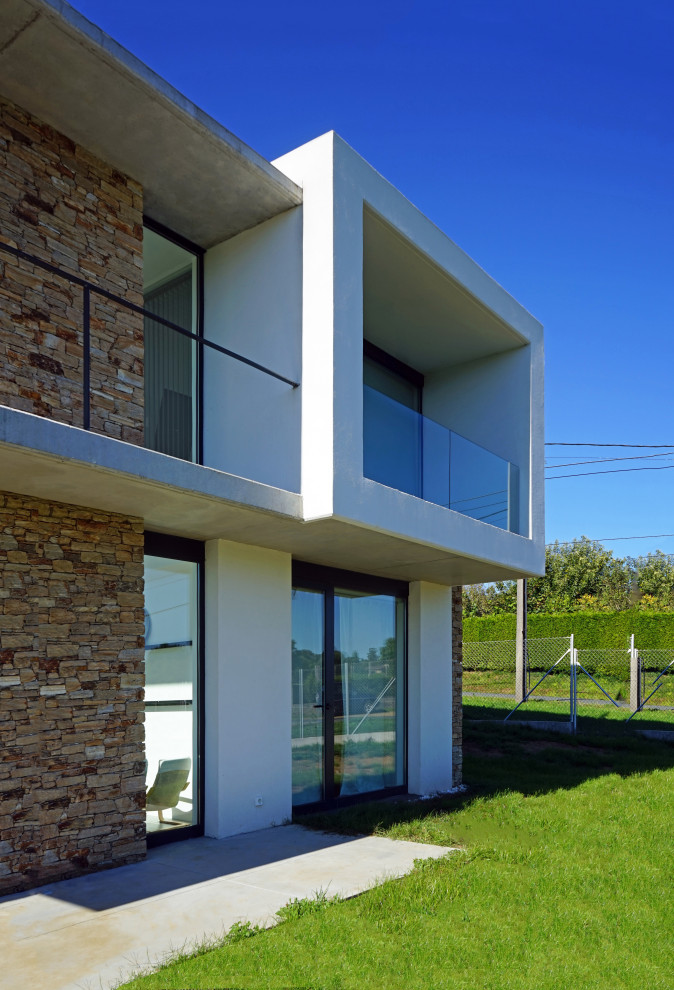 Modelo de fachada de casa blanca y blanca moderna de tamaño medio de dos plantas con revestimientos combinados, tejado plano y tejado de varios materiales