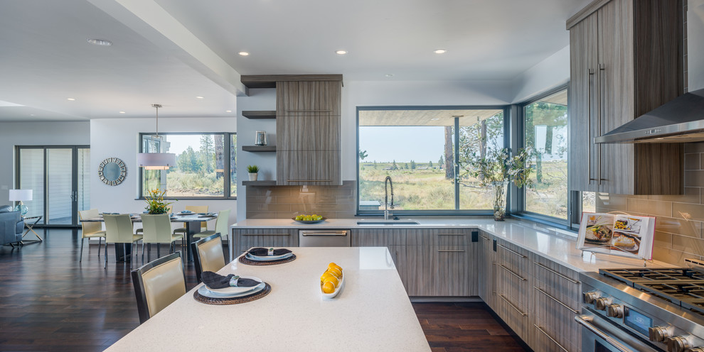 Photo of a mid-sized contemporary l-shaped eat-in kitchen in Other with an undermount sink, flat-panel cabinets, grey cabinets, quartz benchtops, beige splashback, glass tile splashback, stainless steel appliances, dark hardwood floors and with island.