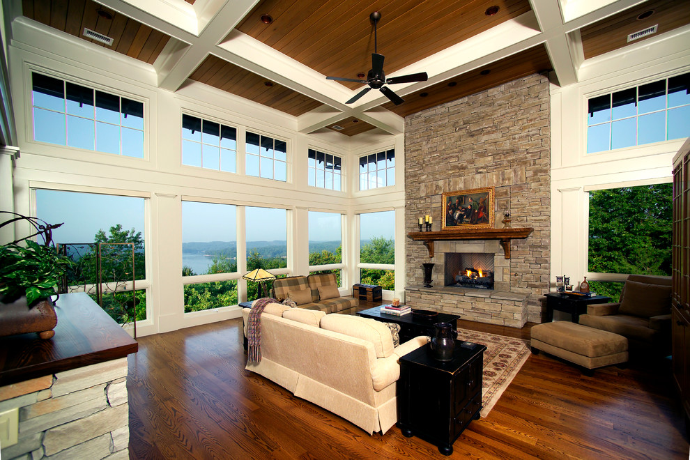 Traditional sunroom in Other with medium hardwood floors, a standard ceiling, brown floor and a stone fireplace surround.