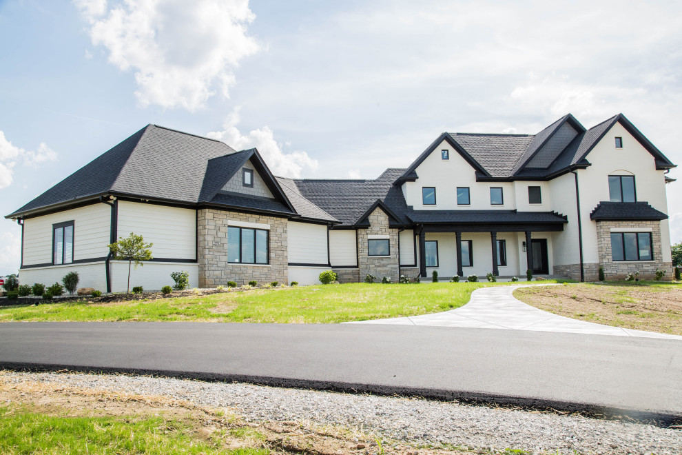 Großes, Zweistöckiges Country Einfamilienhaus mit Mix-Fassade, beiger Fassadenfarbe, Satteldach, Schindeldach, schwarzem Dach und Verschalung in Indianapolis