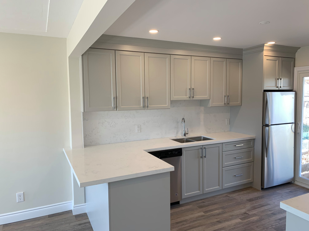 Eat-in kitchen - mid-sized transitional galley medium tone wood floor eat-in kitchen idea with an undermount sink, shaker cabinets, gray cabinets, quartz countertops, white backsplash, quartz backsplash, stainless steel appliances, a peninsula and white countertops