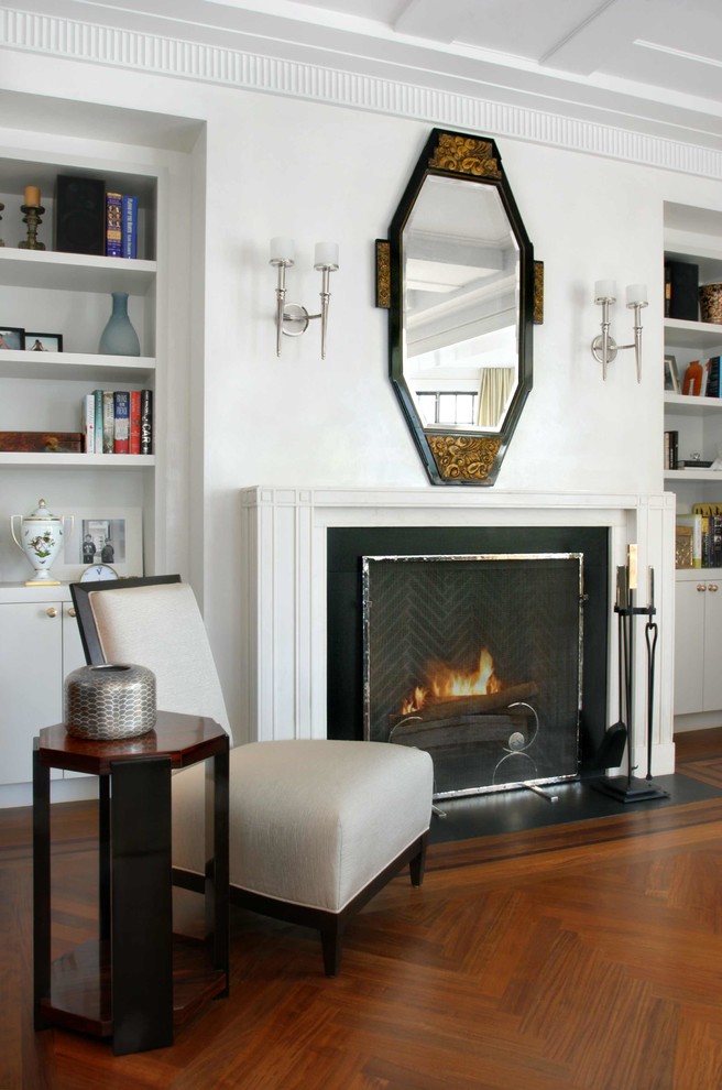 Photo of a small contemporary formal open concept living room in New York with white walls, medium hardwood floors, a standard fireplace, a stone fireplace surround and a concealed tv.