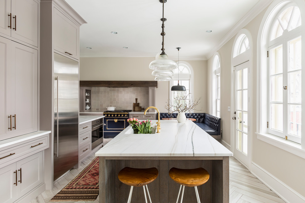 Photo of a large transitional l-shaped eat-in kitchen in Minneapolis with an undermount sink, recessed-panel cabinets, grey cabinets, marble benchtops, grey splashback, ceramic splashback, coloured appliances, porcelain floors and with island.