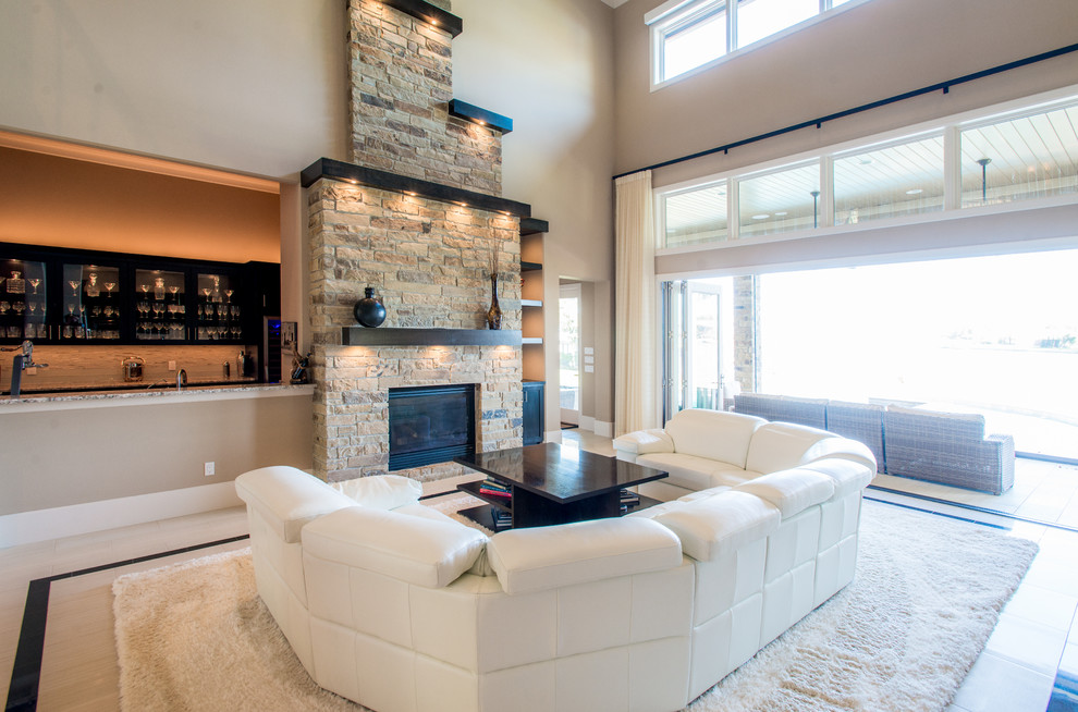 Large modern open concept living room in Houston with a home bar, beige walls, porcelain floors, a standard fireplace and a stone fireplace surround.