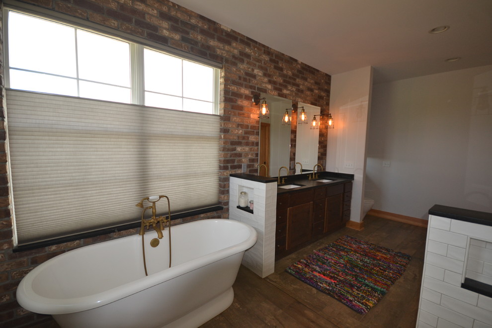 Freestanding bathtub - mid-sized transitional master dark wood floor and brown floor freestanding bathtub idea with flat-panel cabinets, dark wood cabinets, an undermount sink and solid surface countertops