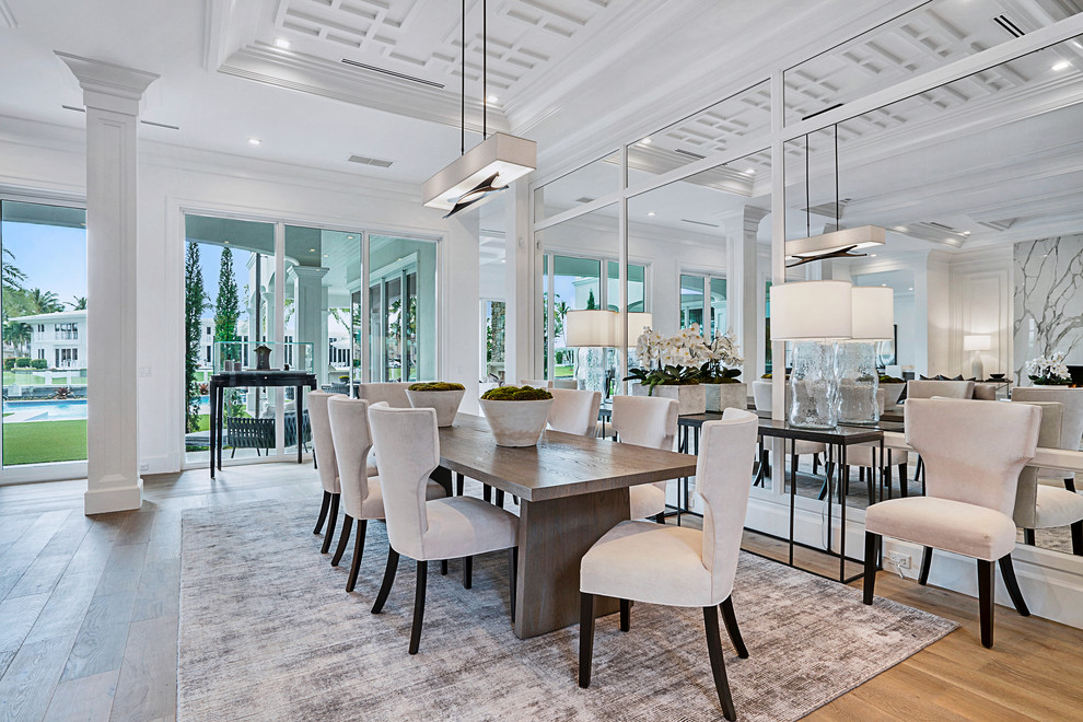 Photo of a transitional open plan dining in Miami with white walls, medium hardwood floors and brown floor.