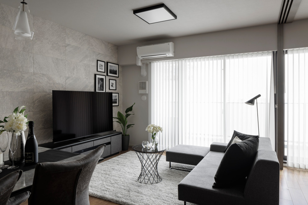 На фото: гостиная комната с серыми стенами, полом из фанеры, отдельно стоящим телевизором, серым полом, потолком с обоями и обоями на стенах с