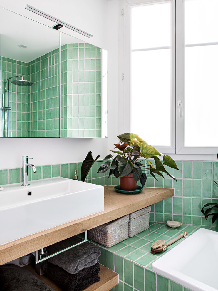 This is an example of a mid-sized contemporary master bathroom in Paris with open cabinets, an undermount tub, a two-piece toilet, green tile, ceramic tile, white walls, ceramic floors, a drop-in sink, wood benchtops, white floor, a laundry, a single vanity and a floating vanity.
