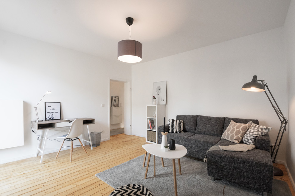 Kleines Nordisches Wohnzimmer mit hellem Holzboden in Köln